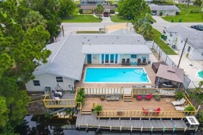 Ein Wohnhaus mit Swimmingpool, Terrasse und Sitzgelegenheit im Freien.