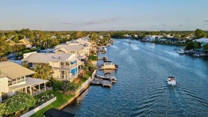 A riverfront property with multiple boats docked, a marina, and residential buildings along the water. - Sunsets at Snowmas Pooch Friendly Stunning Views (Noosa)