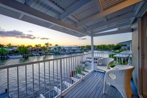 A covered balcony with a view of a marina, outdoor seating, and a railing. - Sunsets at Snowmas Pooch Friendly Stunning Views (Noosa)
