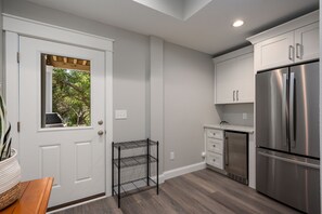 A kitchen with white cabinets, a stainless steel refrigerator, and a wooden countertop. - Benders Beach Bungalow: New Construction, Golf Views, Elevator, Community Pool and Tennis Courts (Nags Head)