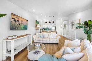 A modern living room with a sofa, coffee table, and artwork on the walls.