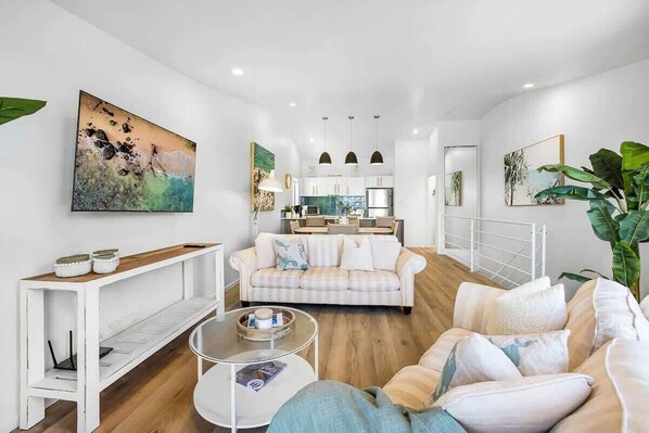 A modern living room with a sofa, coffee table, and artwork on the walls.