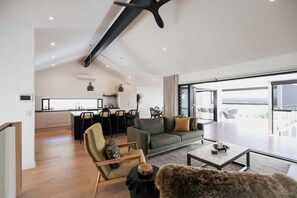 A modern living space with a kitchen, dining area, and a large window offering a view.