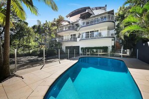 A multi-story residential building with a swimming pool in the foreground. - Hamptons Style Beach Retreat in Noosa s Heart (Noosa)