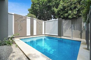 Guests can enjoy a refreshing swim in the pool surrounded by lush gardens.