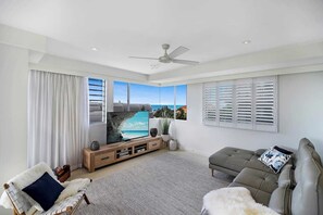 Relax in this stylish living room with a large flat-screen TV, comfortable sofa, and ocean views.