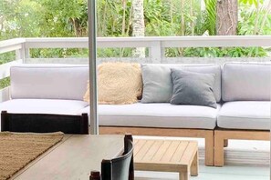 Relax in a serene outdoor space with a comfortable sofa and dining area.
