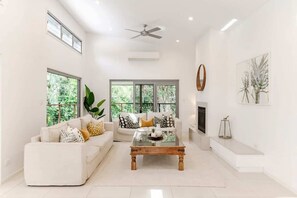 A spacious living room with a white sofa, a coffee table, and a fireplace.