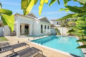 A modern house with a swimming pool, surrounded by tropical plants. - Seahorse Family & Pooch Friendly Waterfront Home (Noosa)