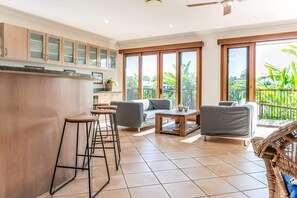 A modern living space with a kitchen, bar area, and seating with a view. - Seahorse Family & Pooch Friendly Waterfront Home (Noosa)