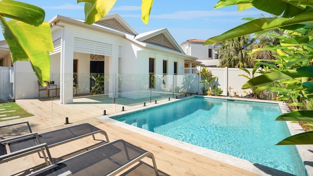 A modern house with a swimming pool, a covered patio, and lush tropical plants. - Seahorse Family & Pooch Friendly Waterfront Home (Noosa)