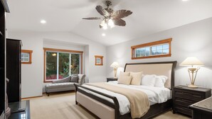 A bedroom with a large bed, bedside tables, a bench, and a ceiling fan. - Poppyrosa Estate with mountain views minutes from Seattle, Bellevue, Sea-Tac (Issaquah)