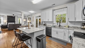 A modern kitchen with white cabinets, a granite countertop, and a built-in dishwasher. - Stunning 5 bedroom/3 bath home in Hope Valley Farm (Durham)