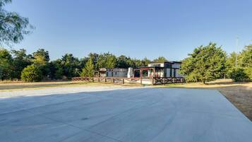 Guests can relax in a serene outdoor space surrounded by lush greenery and a modern structure.