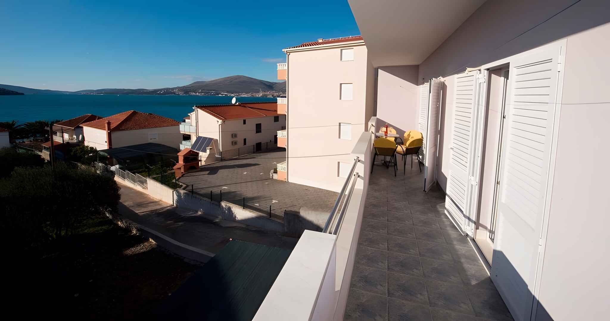 Un balcon avec vue sur la mer et les bâtiments.