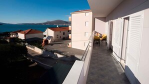 A balcony with a view of the sea and buildings. - Holiday flat with a beautiful view (Okrug Gornji)