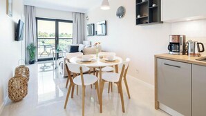 Un appartamento moderno con zona pranzo, cucina e balcone.