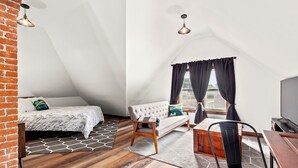Une chambre de style loft moderne, avec un lit en mezzanine, un canapé, une table à manger et un téléviseur.