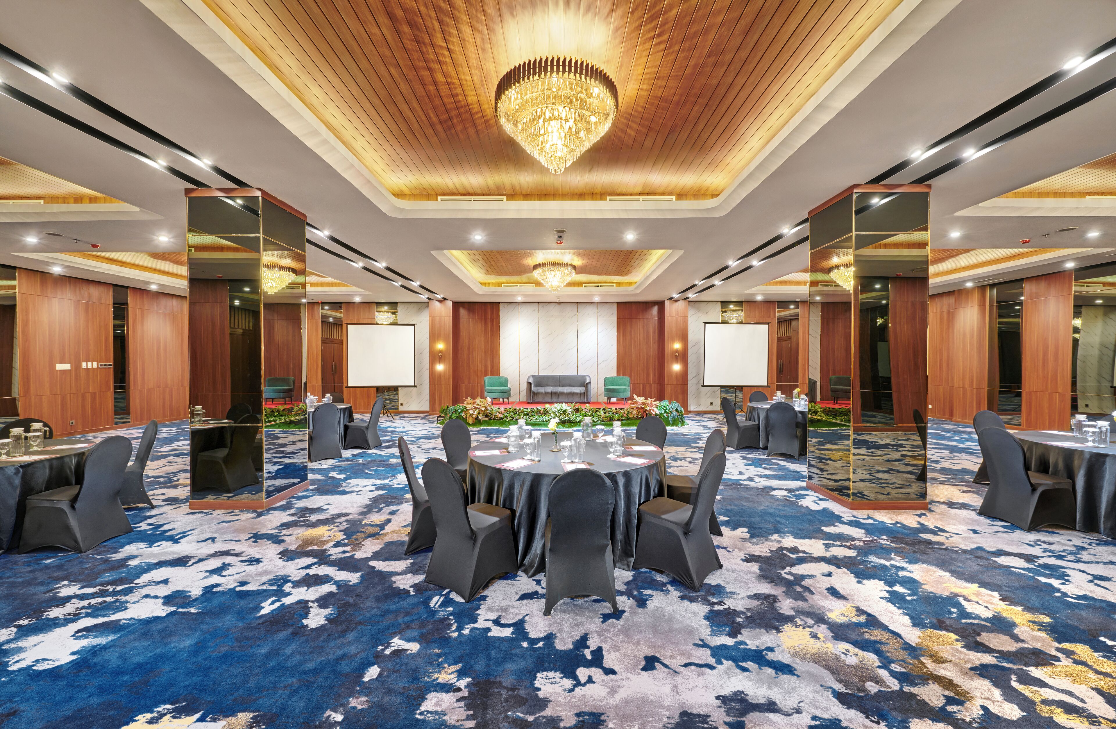 A conference room with a round table, chairs, and a chandelier.