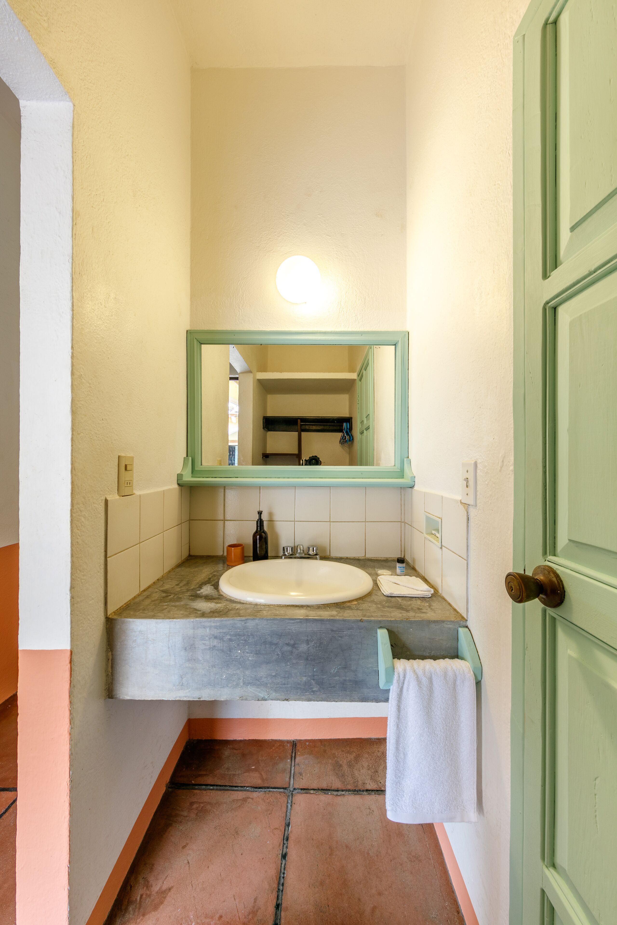 A bathroom with a white sink, a mirror, and a towel rack.