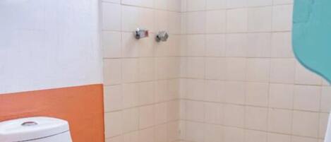 A small bathroom with a toilet, a shower stall, and a window.