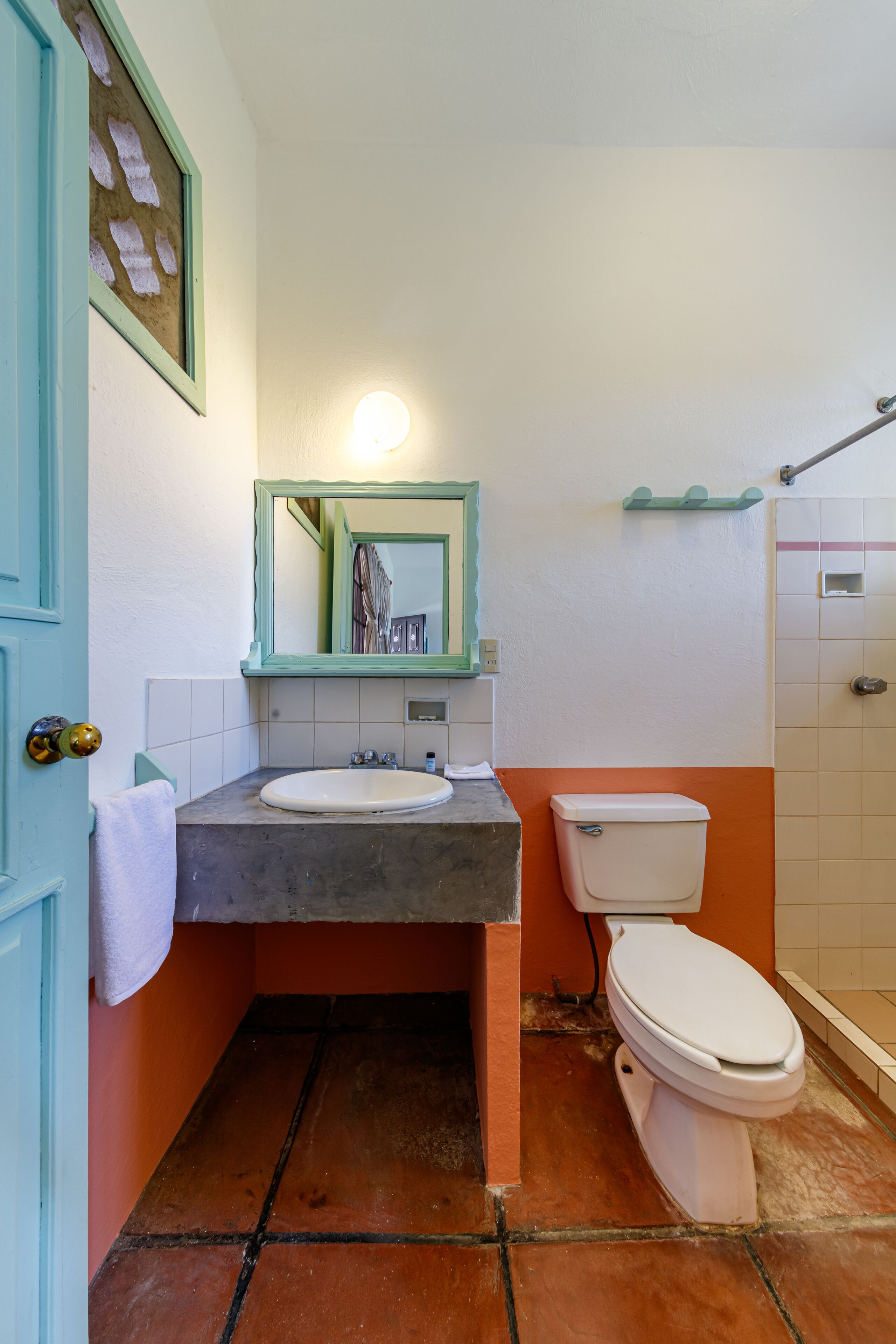 Un baño con lavamanos blanco, inodoro y zona de ducha.