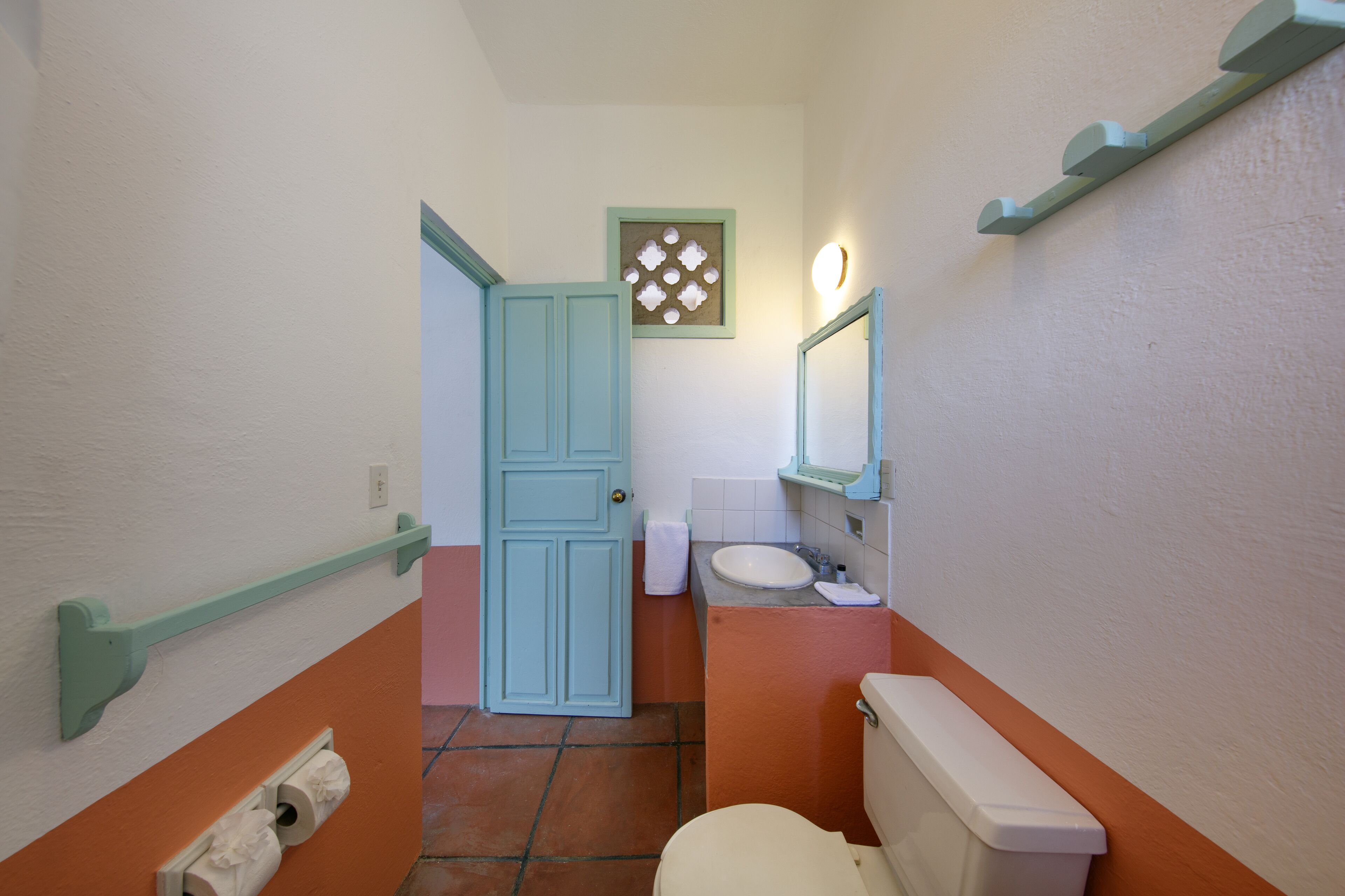 A bathroom with a toilet, sink, and a towel rack.