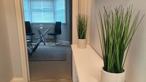 A hallway with a white console table and a potted plant. - Stunning 1-Bed Apartment in Southsea (Southsea)
