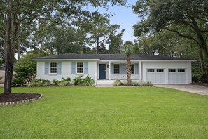 A single-story house with a front porch, a garage, and a well-maintained lawn.