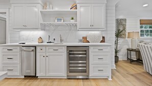 Een moderne keuken met witte kasten, roestvrijstalen apparatuur en een centraal eiland.