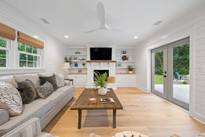 A spacious living room with a sofa, coffee table, and fireplace.