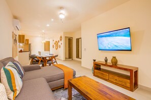 A living room with a sofa, coffee table, TV, and a wooden console. - Santamar by TAO (Akumal)
