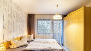 Une chambre à coucher avec un lit, des rideaux, une fenêtre et une armoire.
