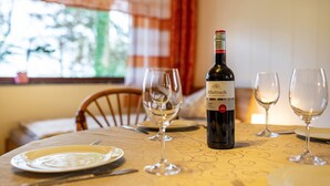 Une table à manger avec une bouteille de vin, des verres et des couverts.