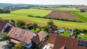 Een woonwijk met huizen, een zwembad en groene velden.
