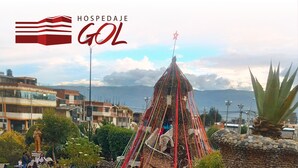 Un hotel con un diseño arquitectónico único, que destaca por una torre imponente y un jardín ajardinado.