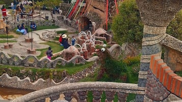 A hotel with a unique architectural design, featuring a prominent tower and a landscaped garden.