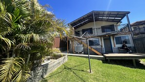 A two-story house with a covered patio and a visible staircase. - Ocean-View Retreat for Family Getaways
 (Cringila)