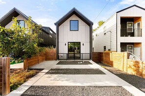 Stylish entrance to a residential building with a central entrance and two smaller structures.