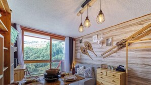 Interior acogedor de una cabaña con comedor, cama y una pared de madera decorada.