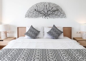 A bedroom with a bed, two patterned pillows, a wall-mounted tree artwork, and bedside lamps. - 2 Bedroom Villa In Seminyak With Private Pool (Bali)
