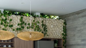 Eine moderne Küche mit einer Steinwand, Holzschränken und einem eingebauten Kühlschrank.