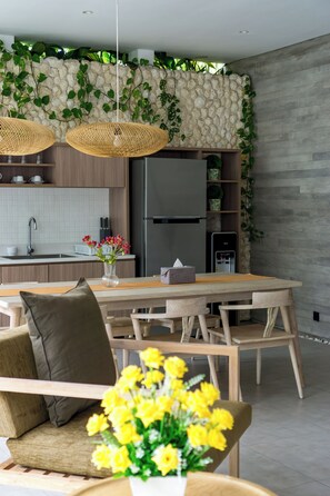 A modern kitchen with a stone wall, wooden cabinets, and a built-in refrigerator. - 2 Bedroom Villa In Seminyak With Private Pool (Bali)