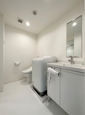 A modern bathroom with a toilet, a washing machine, and a sink. - New Studio Apt in the City Center for 6Ppl (Naka Ward, Hiroshima)