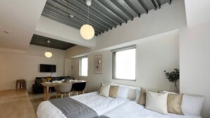 A modern bedroom with a large bed, a desk, and a chair.