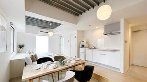 A modern kitchen with white cabinets, a microwave, and a stove.