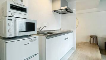 Kylskåp, mikrovågsugn, spishäll och grytor/köksredskap