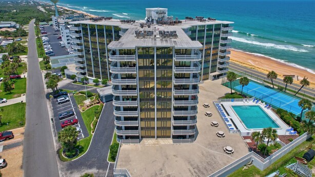 Un hôtel à plusieurs étages doté d’une piscine sur le toit et offrant une vue sur la plage.