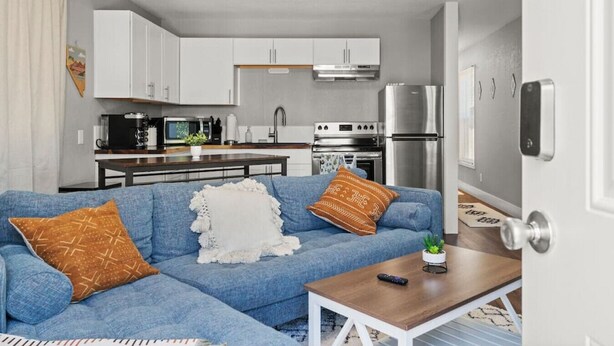 A compact living space with a kitchenette, a sofa with patterned cushions, and a small table. - Tranquil Retreat: Cozy 2Bed, 1Bath Oasis in Fallon (Fallon)