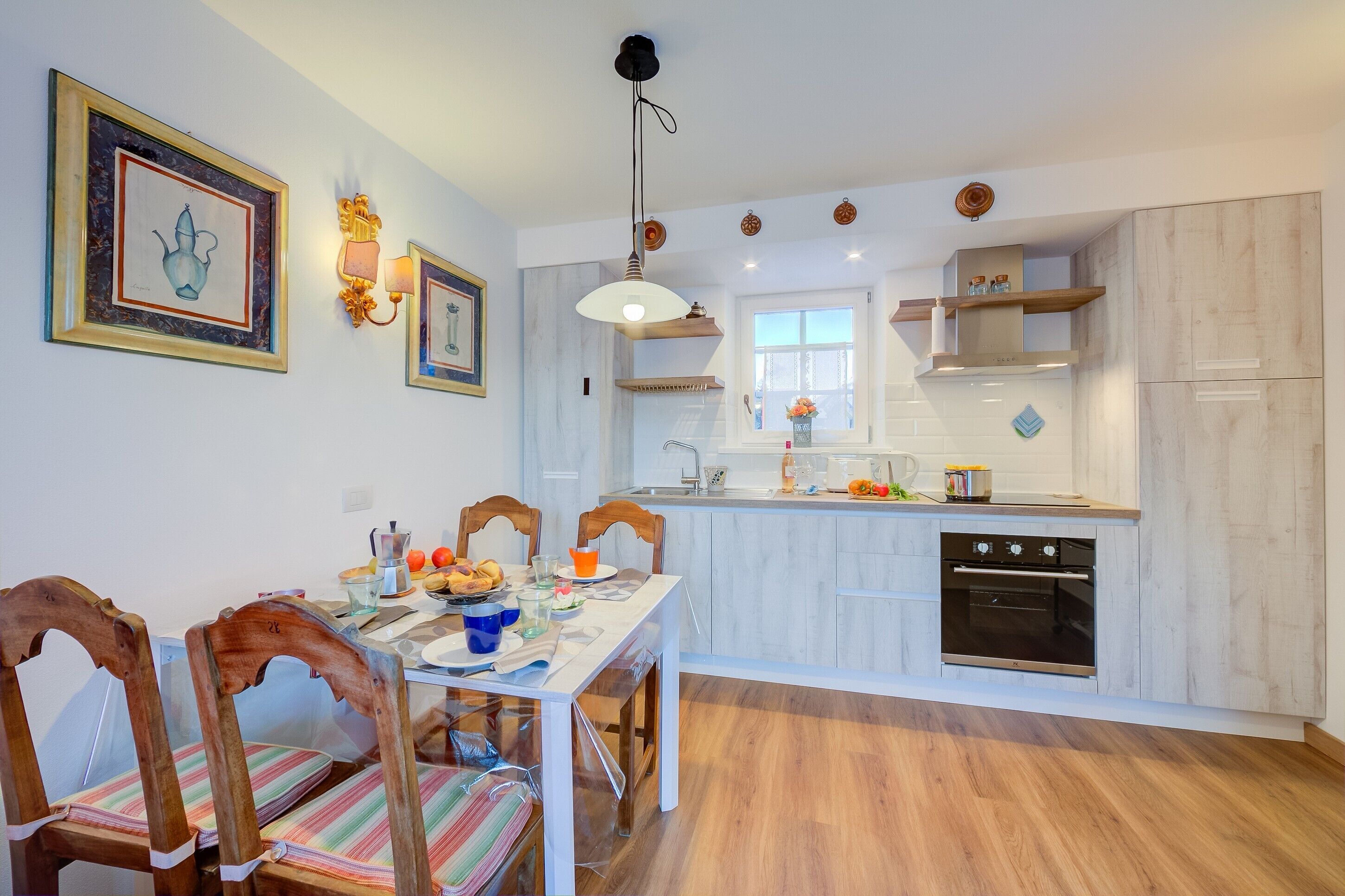 A kitchen with a dining table, chairs, and a window.